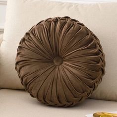 a brown pillow sitting on top of a white couch