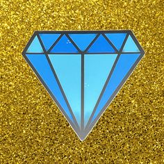 a blue diamond sticker sitting on top of a gold glitter background with the shape of a diamond