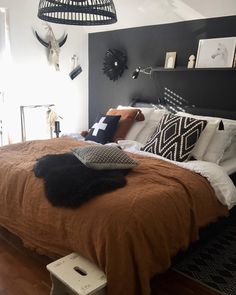 a bed that has some pillows on top of it in a room with wood floors