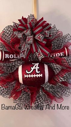 a red and white football wreath with the letter a on it, hanging from a door