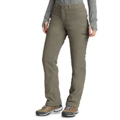 a woman in grey sweater and khaki pants standing with her hands on her hips