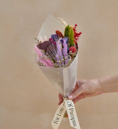 a person holding a bouquet of flowers in their hand with a sign that says sorry to you