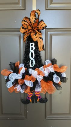 a door hanger decorated with orange and black mesh wreaths that says boo on it