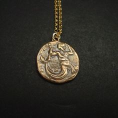 Handmade Greek coin reproduction of merman Triton, son of Poseidon necklace.Triton, son of Poseidon and Aphrodite, striking downward with a trident and holding fish. Triton is the messenger of the big sea. Like his father he carried a trident, but his special attribute was a twisted conch shell on which he blew to clam or raise the waves.- Handmade charm.- Solid yellow bronze also called jewelry gold bronze coin.- Nickel free- 14k gold filled chain - Gold filled has 100 times more gold than plat Bronze Coin Pendant Necklace, Bronze Brass Coin Necklace With Round Pendant, Symbolic Coin-shaped Brass Necklaces, Symbolic Brass Medallion Coin Necklace, Symbolic Brass Coin Necklace With Round Pendant, Bronze Coin-shaped Brass Necklace, Bronze Coin Shaped Necklace, Bronze Coin Necklace In Brass, Bronze Coin Shaped Brass Necklace