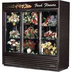 a display case with flowers and vases in it's glass front doors that say fresh flowers