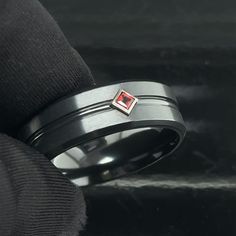 This modern Black Zirconium Ring with a geometric design is enhanced by color contrasts. In the center of this Black Wedding Band there is a beautiful square Garnet that has a rich deep hue of orange/red. The gemstone is set sideways in a solid gold bezel. You can request different birthstones or any other precious stones . The ring measures 8mm in width. The profile of the ring is flat with a center groove and polished beveled edges. The inner part of the ring is rounded for Comfort Fit. This s Mens Promise Ring Red, Zirconium Ring, Black Zirconium Ring, Handwritten Text, Engraved Handwriting, Ring Man, Black Wedding Band, Personalized Ring, Ring Mens