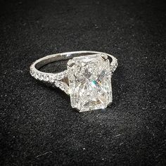 a fancy ring with a princess cut diamond set in it's shants on a black surface