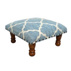 a blue and white ottoman with wooden legs