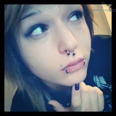 a woman with piercings on her nose and nose ring in front of her face