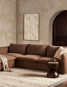 a living room with a large sectional couch and coffee table on the rug in front of it