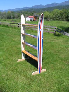 a wooden surfboard rack in the grass