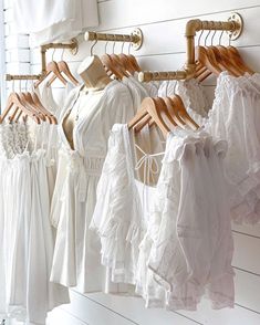 there are many different types of dresses hanging on the clothes rack in front of white walls