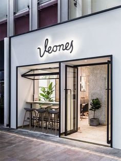 a store front with an illuminated neon sign above the door that reads, vegnes