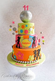 a multi - tiered cake decorated with disco balls and stars