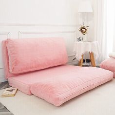 a pink couch and chair in a room with white walls, flooring and windows