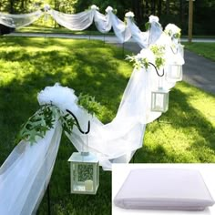 a row of white lanterns sitting on top of a lush green field