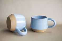 two blue cups sitting next to each other on a table