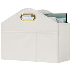 a white leather storage bin with gold handles and file folders in the bottom section