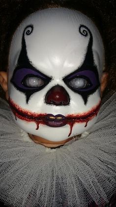 a close up of a person wearing a clown mask