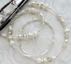 CJ's Inspirations "Creamy Pearl" This beautiful lanyard was made with a collection of sparkling crystals, glass beads, and glass pearls. It makes a wonderful addition to your lanyard collection or a great gift for others. Features and Options: NEW: This eyeglass lanyard can also be converted to a mask lanyard so you never have to set your mask down when you're eating or need a break. The lanyard is connected using small jump rings, as shown in the final photo. To ensure durability and long-lasti White Glasses Chains With Lobster Clasp And Round Beads, Lanyard Crystals, Pearl Mask, Beaded Eyeglass Chain, Glasses Lanyard, Glasses Chains, Mask Lanyard, Need A Break, Eyeglass Chain