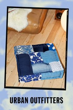 an image of a blue and white patchwork blanket on the floor with text that reads urban outfitters