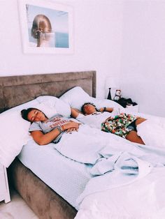 two people laying in bed next to each other