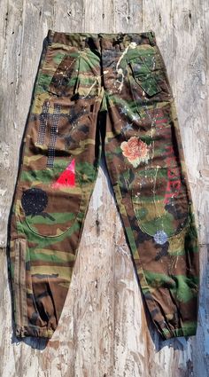 If you love the military style, our military cargo pants will be irresistible to you. Made with high-quality materials and embellished with manual workmanship, these pants are unique and original. Each piece is created with attention to detail, with practical pockets and handcrafted decorations that give a distinctive character. The production is not in series: each piece is handmade in Italy, thus guaranteeing an exclusive and tailor-made product for those looking for something special. The photos shown are indicative of the general style, but each pair of pants features similar but unique decorations, making each piece a work of art in itself. Thanks to the limited edition and craftsmanship, you will have a product that not only completes your outfit with a military touch, but that stand Army Cargo Pants Outfit, Upcycle Pants, Cargo Camo Pants, Army Cargo Pants, Army Clothes, Military Cargo Pants, Army Style, Cargo Pants Outfit, Style Trousers