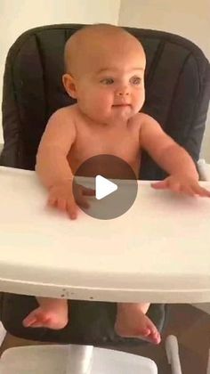 a baby sitting in a high chair with his hands on the table and looking at the camera