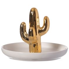 a gold cactus sitting on top of a white plate