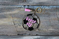 a keychain with a soccer ball and the words reese 12 on it hanging from a wooden background