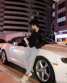 a woman leaning on the hood of a white car