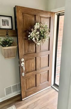 a wooden door with a wreath on the front and side panels, in an entryway