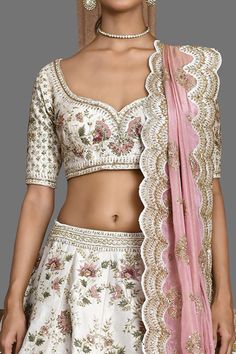 Ivory attached cancan lehenga with zari thread, sequin, cutdana embroidery in floral pattern. Paired with half sleeve padded blouse and scallop bordered dupatta.
Components: 3
Pattern: Embroidery
Type Of Work: Zari thread, sequin, floral
Neckline: Leaf neck
Sleeve Type: Half
Fabric: Raw Silk
Color: Ivory
Other Details: 
Lehenga Length: Approx 45-46 inches
Panelled lehenga
Side and back tassel tie-up
Contrast embroidered sheer dupatta
Occasion: Bride - Aza Fashions White Raw Silk Lehenga For Reception, Cream Resham Embroidery Set For Ceremony, Cream Ceremony Set With Resham Embroidery, Traditional Cream Lehenga With Unstitched Blouse, White Raw Silk Choli For Wedding, White Raw Silk Sets For Reception, White Raw Silk Choli With Cutdana, White Raw Silk Choli With Pallu, White Raw Silk Choli With Pallu Detail