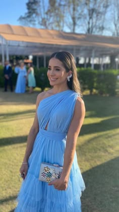 a woman in a blue dress standing on the grass