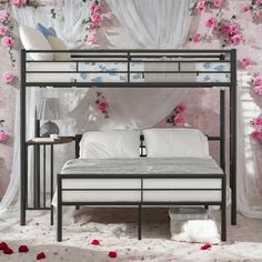 a metal bunk bed with pink flowers on the wall