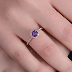 a woman's hand with a diamond and amethoraite ring on it