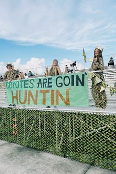 two women in camouflage outfits holding a sign that says boycotts are gon huntin