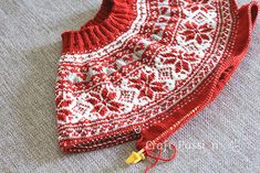 a red and white sweater laying on the floor