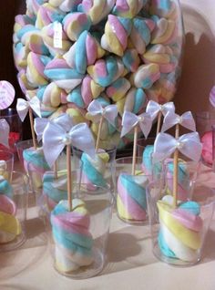 a table topped with lots of candy covered lollipops and marshmallows