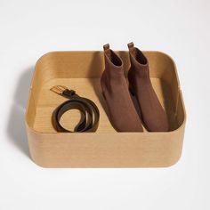 a pair of brown socks sitting inside of a wooden box next to a shoelace