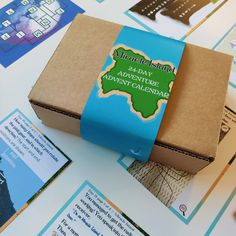 a brown box with a blue ribbon around it on top of a table covered in cards