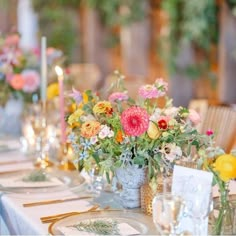 the table is set with flowers and candles