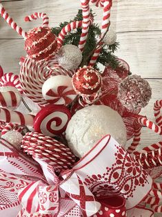 candy canes and candies are arranged in a christmas wreath on a wooden table