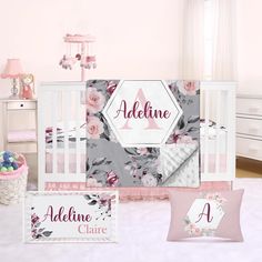 a baby crib bedding set with pink and gray flowers on it, next to a teddy bear