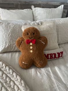 a brown teddy bear sitting on top of a bed