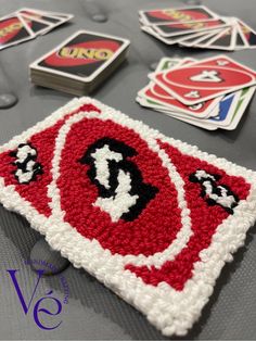 a table topped with lots of playing cards on top of a gray surface and surrounded by magnets