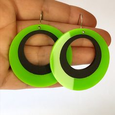 a pair of neon green and black hoop earrings in the shape of a circle, on a white background