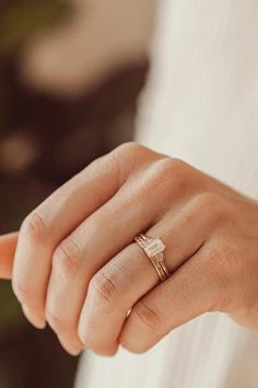 a woman's hand wearing a gold ring with a diamond in the middle and an arrow on it