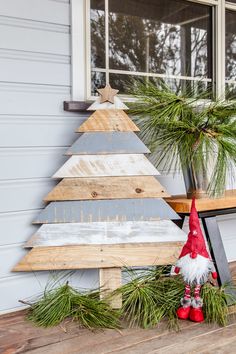 a wooden christmas tree sitting next to a window