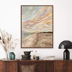 a painting hanging on the wall above a wooden cabinet